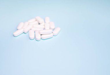 Spilled medications and pills on a blue background. Pharmacology and medicine struggle for health.