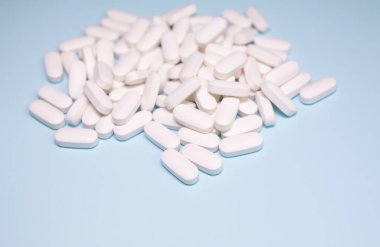 Spilled medications and pills on a blue background. Pharmacology and medicine struggle for health.