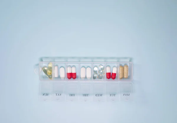 Boîte Plastique Avec Différentes Pilules Sur Fond Bleu Clair — Photo