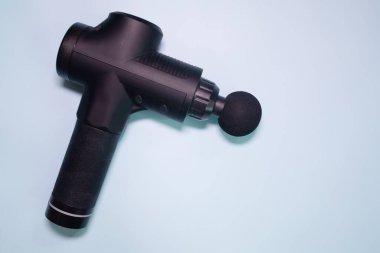 Machine for body massage on blue background. Massage gun.