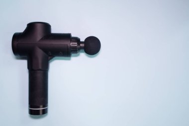 Machine for body massage on blue background. Massage gun.