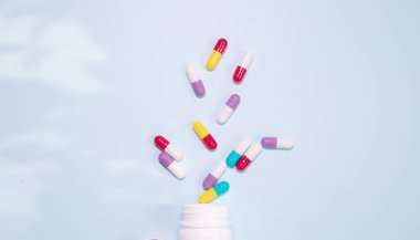 Medicine bottle and pills spilled on a light blue background. Medicines and prescription pills background 