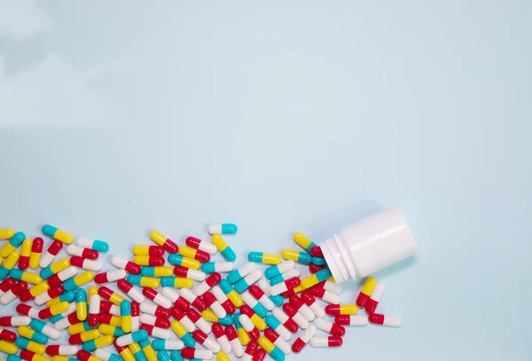 薬瓶と丸薬が青色の背景にこぼれた 薬や処方薬の背景 — ストック写真