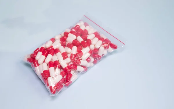 A large amount of pills in a foil bag on a blue background. Drug addiction and drugs.