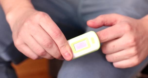 パルス酸素濃度計 コロナウイルスを有する男性患者の指の血中およびパルス中の酸素濃度を測定する現代の非侵襲装置 — ストック動画