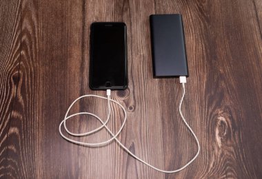Powerbank Smartphone ahşap arka plan üzerinde şarj.