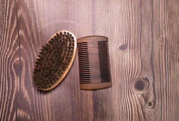 Beard kit comb and brush on wooden background.