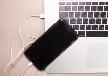 Dizüstü bilgisayara bağlanan akıllı telefon.