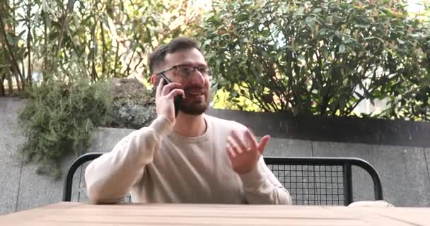 Эмоциональный Бородатый Молодой Человек Разговаривает Помощью Смартфона Открытом Воздухе — стоковое видео