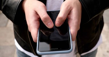 Sokakta akıllı telefon kullanan bir adamın yakın plan görüntüsü