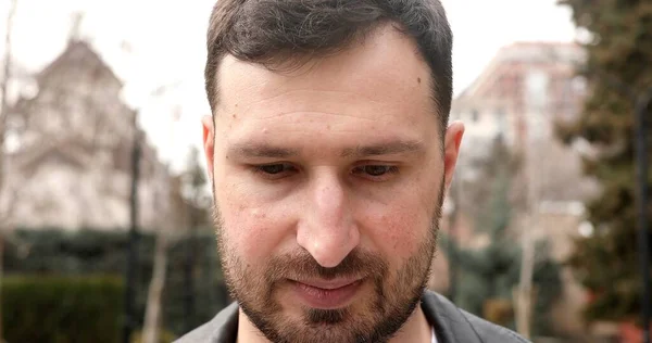 stock image portrait of serious bearded young man looking down outdoors