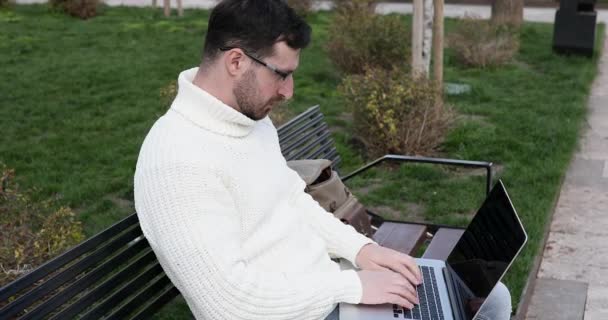Genç Beyaz Adam Bankta Oturuyor Dizüstü Bilgisayar Kullanıyor Baş Ağrısından — Stok video