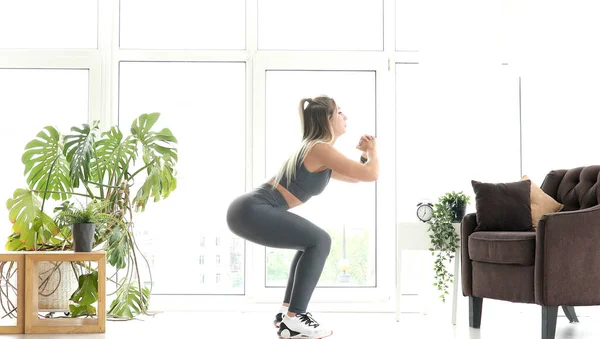 强身健体的女子运动服在明亮的客厅里做运动 — 图库照片