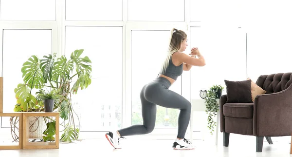 强身健体的女子运动服在明亮的客厅里做运动 — 图库照片