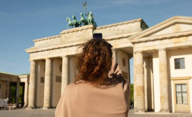 Brandenburg Kapısı 'nı ziyaret eden turist Berlin, Almanya' da akıllı telefonuyla fotoğraf çekiyor.  