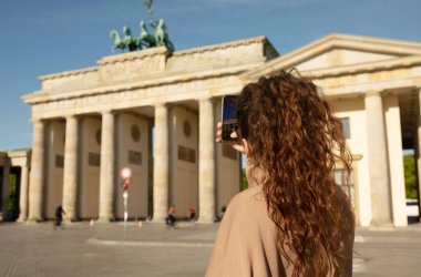 Brandenburg Kapısı 'nı ziyaret eden turist Berlin, Almanya' da akıllı telefonuyla fotoğraf çekiyor.  