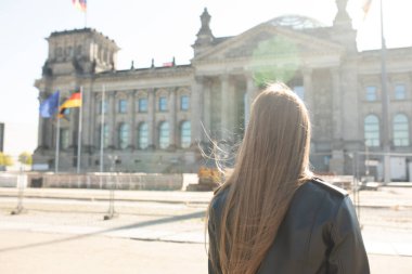 Almanya, Berlin 'deki turnesinde Alman Parlamentosu önünde poz veren genç bir kadın. Bundestag.