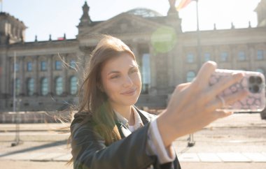 Almanya, Berlin 'deki turnesinde Alman Parlamentosu önünde poz veren genç bir kadın. Bundestag.