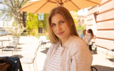 Şehirde kameraya gülümseyen güzel bir genç kadının portresi. 