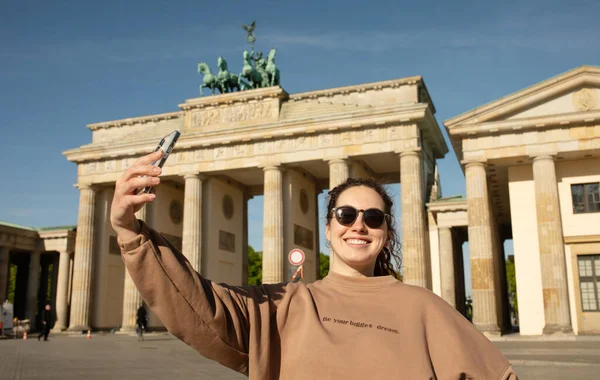Brandenburg Kapısı 'nı ziyaret eden turist Berlin, Almanya' da akıllı telefonuyla fotoğraf çekiyor.  