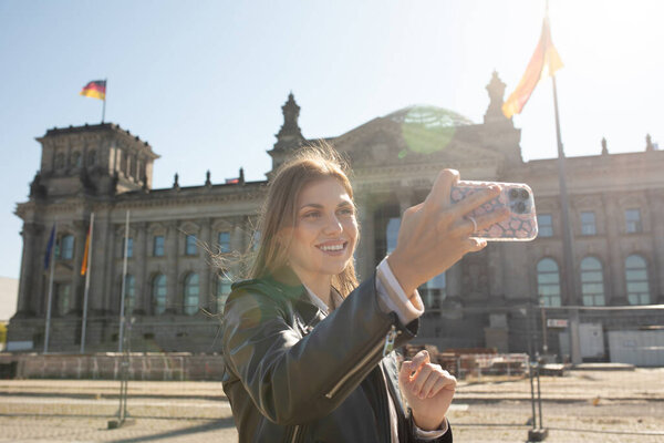 Young woman posing in front of the German Parliament on her sightseeing tour in Berlin, Germany. Bundestag.