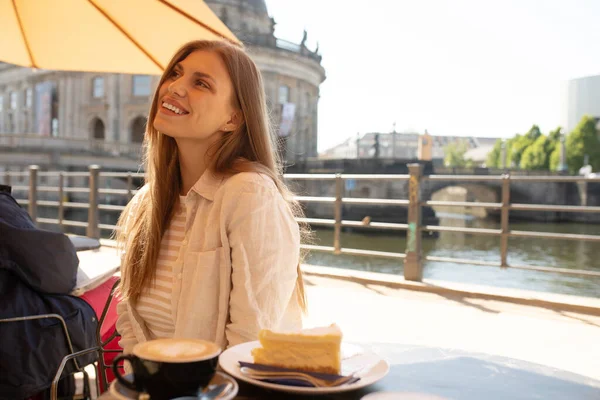 stock image Beautiful woman eating dessert and drink coffee at outdoors cafe