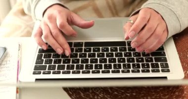 Evde dizüstü bilgisayarla çalışan genç bir kadının yakın çekim görüntüsü