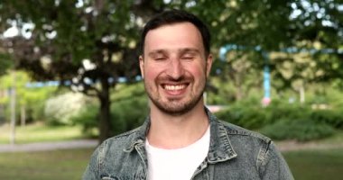 Kameraya gülümseyen yakışıklı genç adamın portresi.