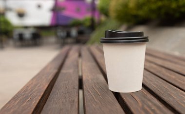 Kahve fincanını kapat ve arka plandaki masaya götür..