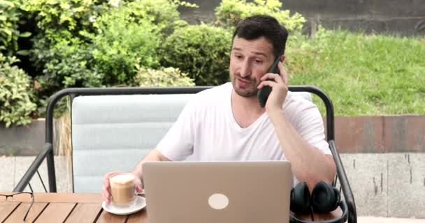 Portret Młodego Brodatego Mężczyzny Rozmawiającego Przez Smartfona Korzystającego Laptopa — Wideo stockowe