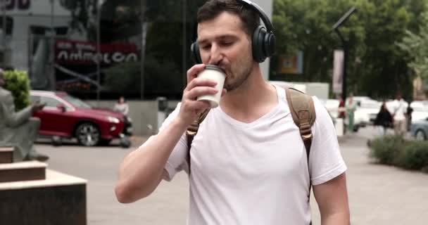 Pohledný Mladý Muž Sluchátkách Pití Kávy Ulici — Stock video