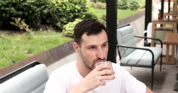 Przystojny Młody Mężczyzna Siedzi Odkryty Kawiarnia Pije Kawę — Wideo stockowe