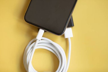 Sarı arka planda cep telefonu ve akıllı telefon için pil. 