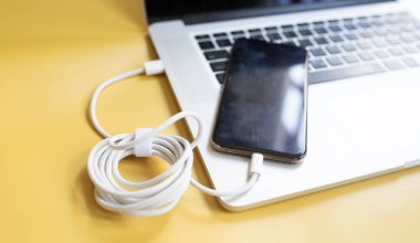 sarı arka planda kablolu bilgisayar ve cep telefonu 