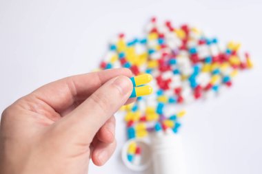 El ele tutuşup ilaç haplarını beyaz masanın arkasına koyun..