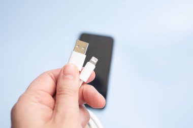 Adam arka planda bize kablo ve akıllı telefon tutuyor