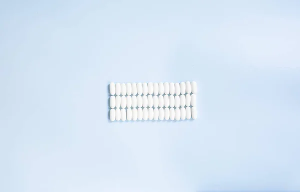 Sacco Pillole Medicinali Sfondo Blu Pillole Bianche Sparse Sul Tavolo — Foto Stock