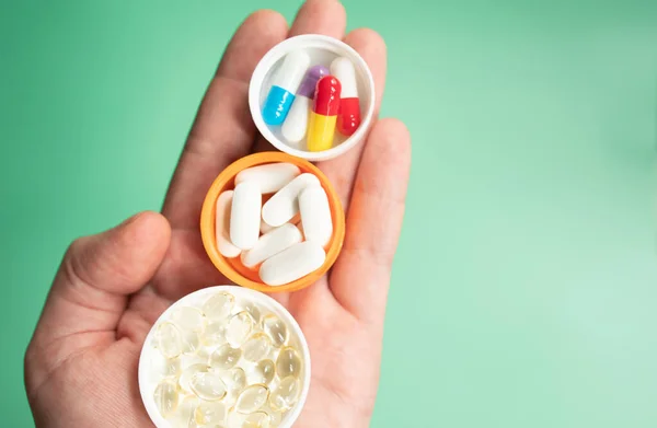 Tutup Tangan Memegang Pil Obat Pada Latar Belakang Hijau — Stok Foto