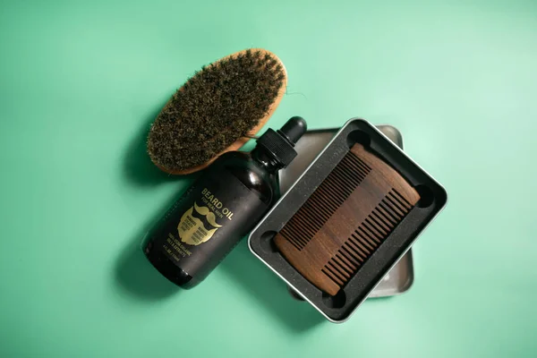 绿色背景的理发店工具 老式木制胡子梳子 胡子油 电动修剪器 刷子和香脂 — 图库照片