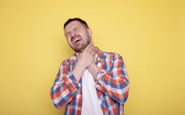 Genç yakışıklı adam boğaz ağrısı çekiyor. 