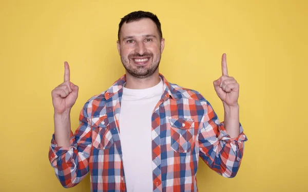 Young Man Casual Clothes Smiling Pointing Something Yellow Background — Stock Photo, Image