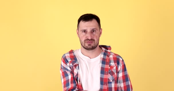 Rozrušený Bezdomovec Mladý Muž Žebrání Při Pohledu Kameru Izolované Žlutém — Stock video