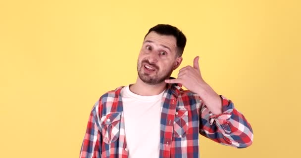 Schöner Junger Mann Zeigt Rufgeste Isoliert Auf Gelbem Hintergrund — Stockvideo