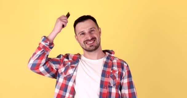 Beau Jeune Homme Peignage Cheveux Isolés Sur Fond Jaune — Video