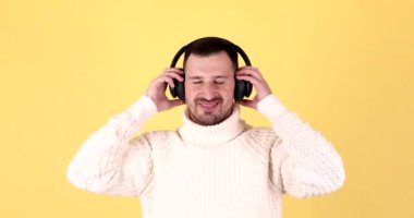 Neşeli sakin genç adam. Kulaklıkla müzik dinle. Dans şarkıları söyle..