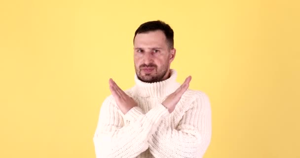 黄色の背景にネガティブな表情をした人を止める男 — ストック動画