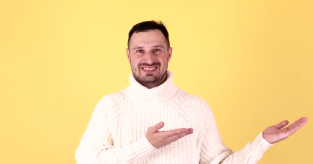 Knappe Man Presenteert Iets Door Palmen Met Gele Achtergrond — Stockvideo