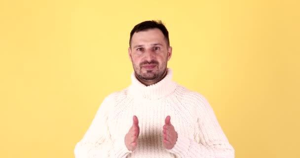 Yakışıklı Adam Sarı Arka Planda Boş Elle Bir Şey Sunuyor — Stok video