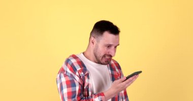 Sinirli adamın telefon konuşması var. Sarı arka plan görüşmeleri sırasında bağıran sinirli adam..