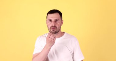 Öpücük yollayan genç adam. Sarı arka planda sevgiyle öpücükler yolluyorum..